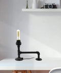 Industrial-style table lamp made with a malleable iron pipe fitting showcasing DIY design with vintage decor feel on a white desk.