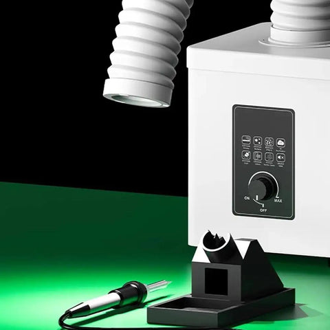 Compact Desktop Solder Fume Extractor With Dual Stage Air Purifier beside soldering iron holder, showcasing control panel and exhaust hose.