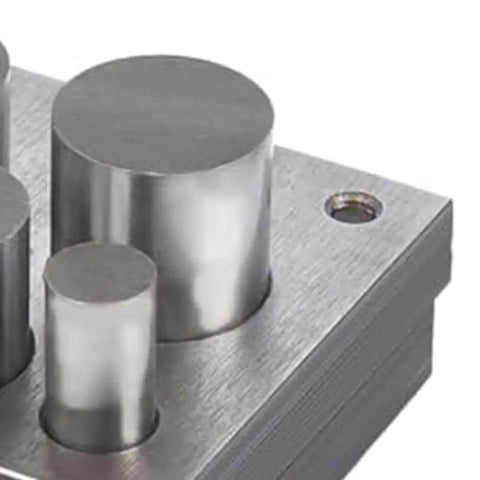 Close-up of 5 Piece Disc Cutter Set for Metal Jewelry Making with round punch sizes on a metal block.