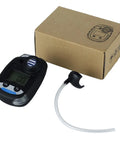 Black handheld ammonia gas monitor with digital display, sensor port, and white sampling tube beside a cardboard box.