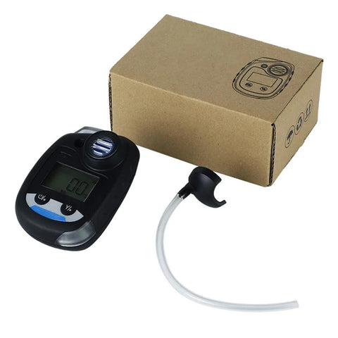 Black handheld ammonia gas monitor with digital display, sensor port, and white sampling tube beside a cardboard box.