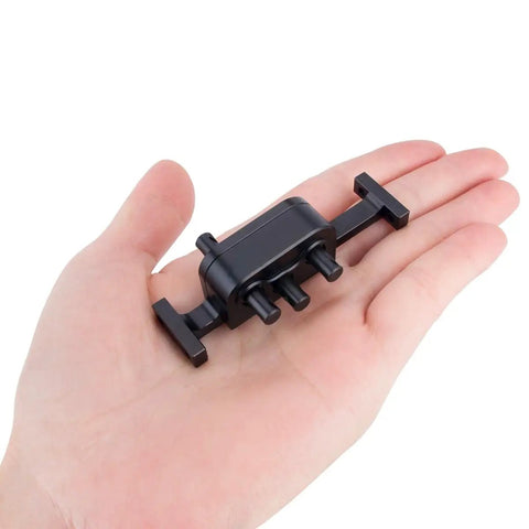 Person holding a small black aluminum beefed up metal transfer case with reverse shaft for 1/10 LCG RC crawler SCX10 chassis upgrade parts.