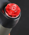 Red anodized Bike Air Valve Top Cap Cover for Suspension Forks, CNC Machined Aluminum, on a bicycle fork