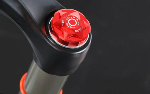 Red anodized Bike Air Valve Top Cap Cover for Suspension Forks, CNC Machined Aluminum, on a bicycle fork