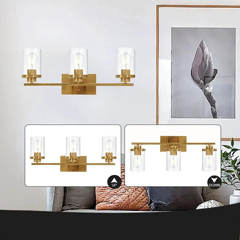 Brushed Brass 3 Light Vanity Light With Clear Glass Shades, Modern Farmhouse Wall Mount Fixture in living room setting.