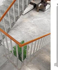 Heavy Duty Stair Railing Spindle System Kit With Pre Drilled Screws And Knockout Build Wrought Iron Handrail Pillars For Deck And Porch No Sweat Install Anti Rust Metal Guard installed on staircase with wooden banister.