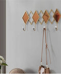 Real Deal Nordic Wrought Iron Wall Hooks For Coats And Keys Heavy Duty Build. Features decorative diamond shapes and white knobs.
