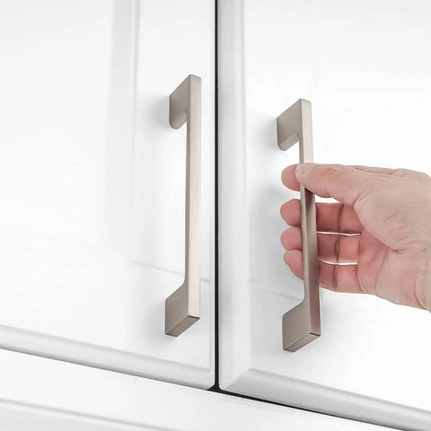 Hand holding 10 Pack 5 Inch Brushed Nickel Kitchen Cabinet Pulls on white cupboard, Silver Nickel Hardware for Cabinets, Drawers, Dresser