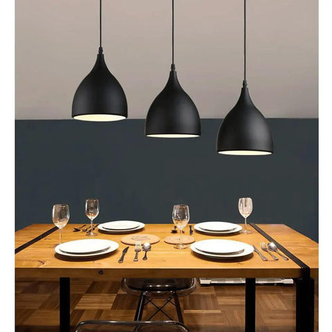 Dark Antique Farmhouse Pendant Light with Single Hanging Shade illuminating a dining table setup with plates.