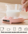 Smart Coffee Mug Warmer With Digital Display And Three Heat Settings Touch Switch Electric Cup Heating Pad To Keep Your Daily Brew Nice And Toasty Ultimate Winter Gift Beige with a glass cup on a pink heating pad.