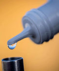 Close-up of DiamondClear Windshield Repair Resin LV Clear Auto Glass Filler For Chips Cracks And Star Breaks with nozzle.
