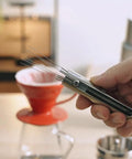 Premium Retractable Espresso WDT Tool All Stainless Steel Coffee Distribution Needle held in hand, ready for use with pour over.