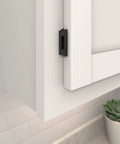 Heavy Duty Quarter Inch Overlay Cabinet Hinges In Slick Matte Black Finish on a white kitchen cabinet door.