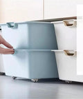 Four Pack Self Adhesive Directional Caster Wheels For Kitchen Cabinets Drawer Units And Storage Bins under a blue storage bin.