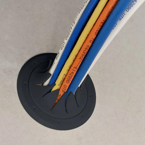 Construct Pro Speedy Spring-Lock cable pass-through port, black, 2-in ID, installed in concrete with colored cables.