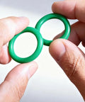 Holding two green rubber seals from 270 Pcs Rubber O Ring Kit With 18 Sizes High Temperature Buna N Seals For Industrial Pneumatic AC Plumbing Repairs