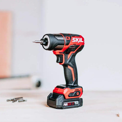 Two Tool Drill Combo Kit With Brushless 12V Drill Driver And One Quarter Inch Hex Impact Driver on table showing red handle grip
