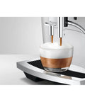 No Sweat Automatic Coffee Maker With Smart Touchscreen And Adjustable Steaming Settings Piano White Finish brewing espresso into a glass cup.