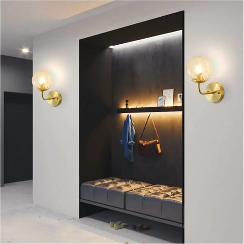 Lit Water Ripple Lampshade Double Gold Wall Sconce Set illuminating a modern hallway with seating and decor.