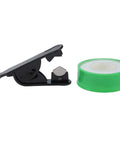 Black tape dispenser with a green roll of adhesive tape against a white background.