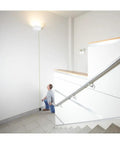Person using Blaze Green Beam Laser Measure Up To 165 Feet With Real Time Distance Reading indoors to measure wall height.