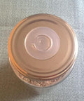 aPraktika vacuum valve for food storage jar, transparent glass container with silver lid (top view)