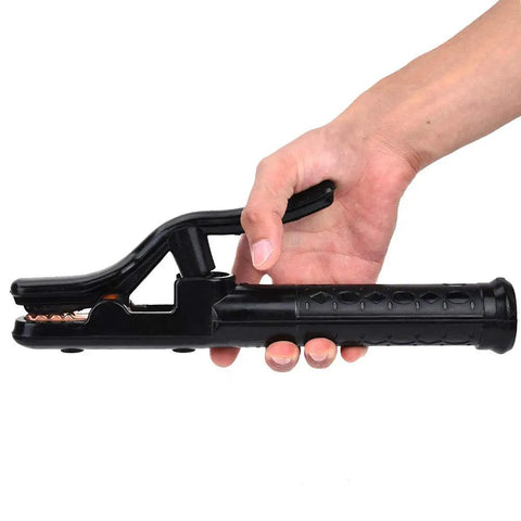 Hand holding a black welding electrode holder with textured handle on a white background.