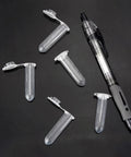 Multiple clear 2 ml microcentrifuge tubes with white snap caps scattered on a dark surface.