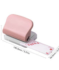 Pink 3 Hole Punch Handheld Paper Puncher With 5 Sheet Capacity And Metal Baked Finish, dimensions shown on desk