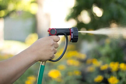 Person using 7 Pattern Watering Nozzle With Thumb Control For Backyard Bosses From Rainlike Shower To Powerful Jet spraying water