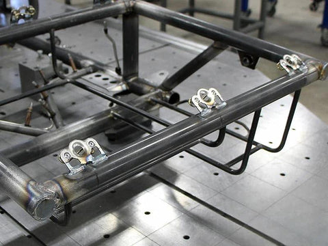 Ten chrome 1/4-turn Dzus fasteners with springs and tab plates mounted on a metal frame for sheet metal panels.