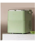 Badass Countertop Ice Maker With Hella Large Storage Producing Fully Automatic Round Cubes in mint green color on marble surface.