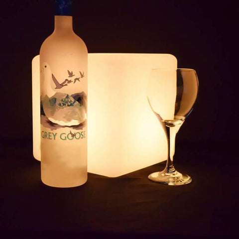 Rechargeable LED Color Changing Cube Light 8 Inch Dimmable With Remote 16 RGB Colors 4 Modes Waterproof Patio Party Ambient Decorative Lamp Perfect For Home Decor And Outdoor Gatherings beside a bottle and a wine glass in dim lighting