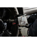 Badass 3/4 Inch Drive Air Impact Wrench Delivering Straight Up 1100 Ft Lbs Max Torque shown in use on a truck wheel.