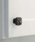 Close-up of solid zinc alloy cabinet pull knob, oil rubbed bronze, installed on white cabinet door, 1-1/8 inch size, 10 pack.