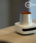 Keep Your Morning Sip Hit The Spot With This Versatile Travel Coffee Mug Warmer That Heats Or Chills Drinks Quickly Ideal For Commutes Desk Work And Home Offices on a wooden table.