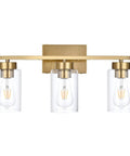 Clean Three Light Bathroom Vanity Wall Sconce In Smooth Brushed Gold Finish With Clear Retro Glass Shades showing three bulbs in a clear glass shade.