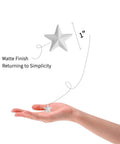 Hand holding White Mini Metal Barn Star 1 Inch with matte finish, part of Set of 27 for Crafts Handcrafted Ornaments with Antique Finish.