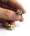 Close-up of solid brass bullet rivets with screw posts held in hand, ideal for custom wallets and rugged backpack repair projects.