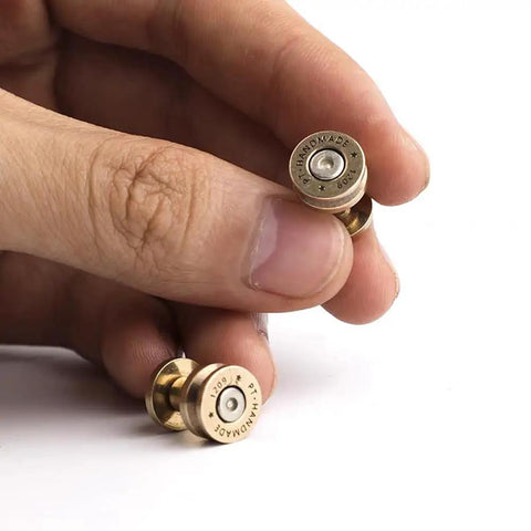 Close-up of solid brass bullet rivets with screw posts held in hand, ideal for custom wallets and rugged backpack repair projects.