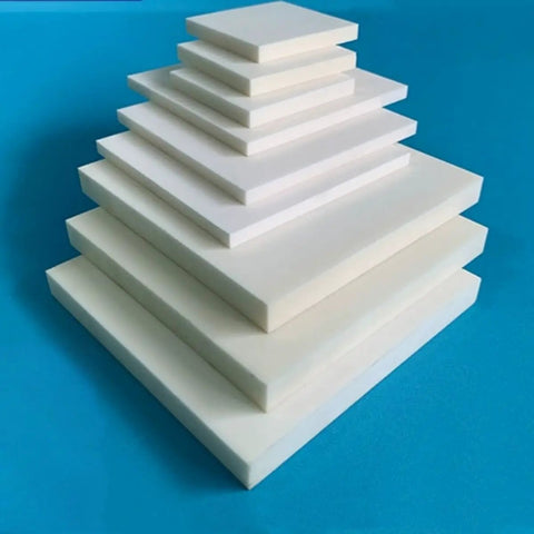 Stack of lab grade 99% alumina ceramic sheet insulators for high temperature substrates, varying sizes, on blue background.