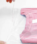 Person sealing a pink t-shirt in a 100 Pack Clear 9x12 Inch Self Adhesive Plastic Bag For Packaging Clothes And T Shirts Peel And Seal.