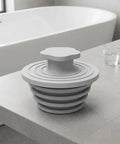 GLSTOY Silicone Bathtub Drain Plug 2 Pack Gray for 1.5 to 2 Inch Drains displayed on a bathroom counter.