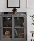 Gray cabinet with glass doors and shelves in a minimalist modern room setup.
