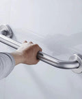 Hand gripping a Heavy Duty Stainless Steel Bathroom Safety Grab Bar With A Tight No Slip Grip For Shower Or Tub Ada Compliant Beefy Handrail Support For Seniors Fly Brushed Finish Eighteen Inch Rig.