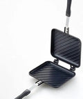 Chomp Out Cheesy, Crispy Panini Wonders With This Aluminum Flip Grill, black nonstick cooking surface and long handle.