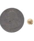 Straight Premium 6MM Gold Filled Round Beads For Jewelry Crafting beside a quarter for size comparison.