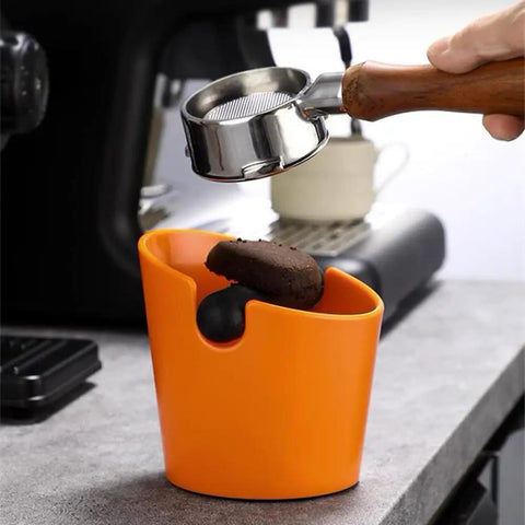 Orange ABS Coffee Knock Box 2.5L Open Top With Non Slip Base shown on countertop with portafilter knocking out grounds