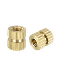 Close-up of two brass knurled threaded insert nuts M3 x 6mm, 5mm OD for DIY projects and furniture joints.