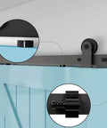 Five And Half Foot Sliding Barn Door Hardware Kit With Adjustable Floor Guide And Top Mount Track For Barn Wood Doors Durable Steel Construction With Nylon Wheel Hangers For Smooth Quiet Operation Frosted Black Finish Fits One And Three Eighths Inch Doors, close-up view of hardware installed on a blue wood door.